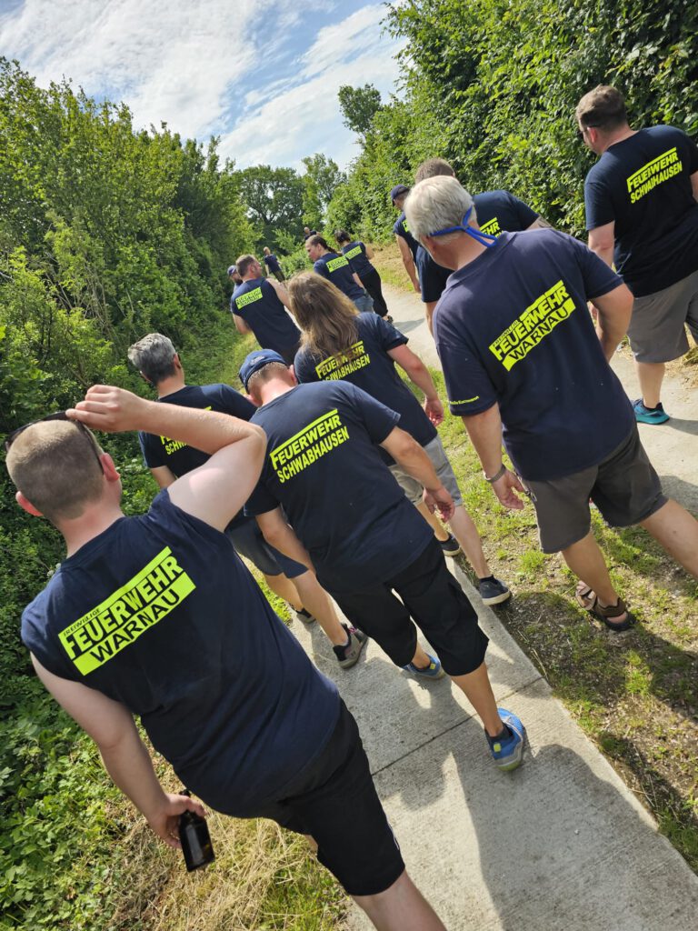 Das Bild zeigt Kameradinnen und Kameraden der freiwilligen Feuerwehren Warnau und Schwabhausen, beim Boßelns auf dem Warnauer Weg.