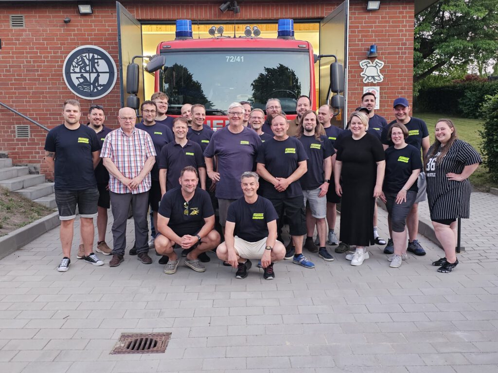 Das Bild zeigt das Gruppenfoto mit Mitgliedern der freiwilligen Feuerwehren Warnau und Schwabhausen vor dem Gerätehaus der Freiwilligen Feuerwehr Warnau.